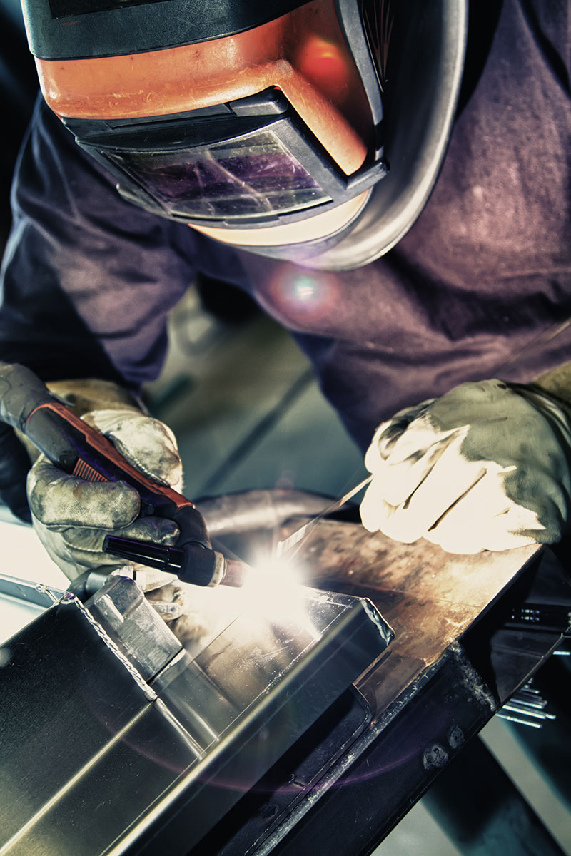 Technician welding on a piece of equipment