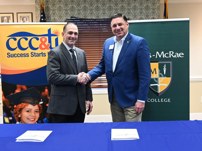 Dr. Mark Poarch and Kevin Phillips shaking hands